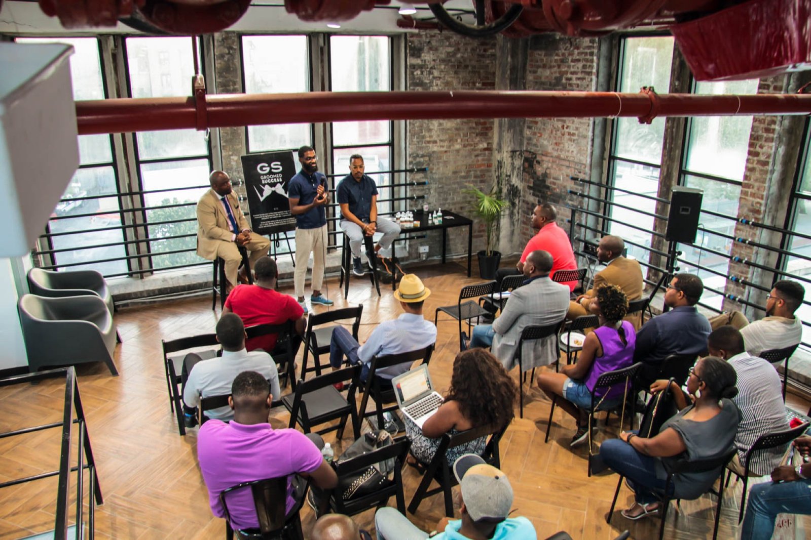 An aerial view of a Gentlemen's Factory cohort workshop session in a Brooklyn loft space