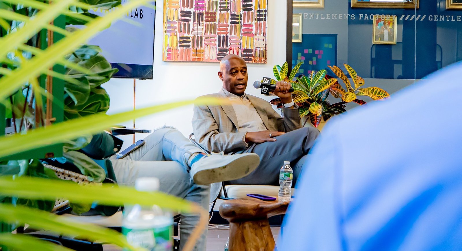 A facilitator holding a GF microphone inside the Gentlemen's Factory Innovation Lab