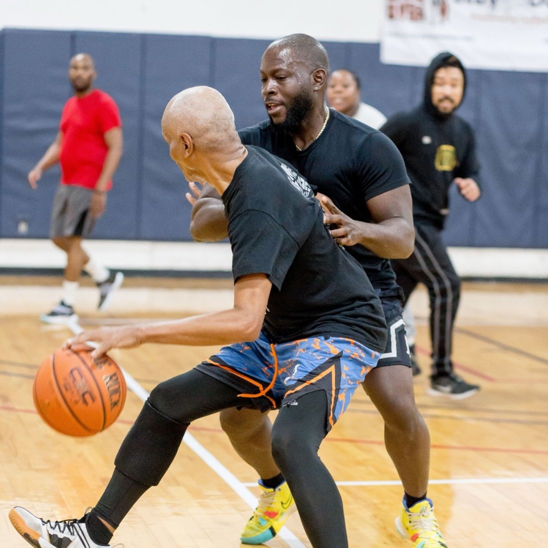 Two members playing pickup basketball in a gym