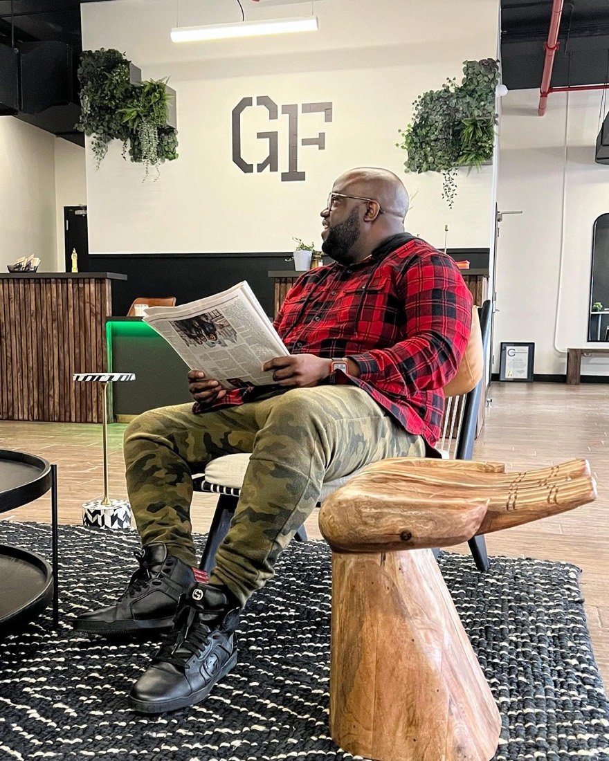 A member reading the newspaper beneath the GF logo