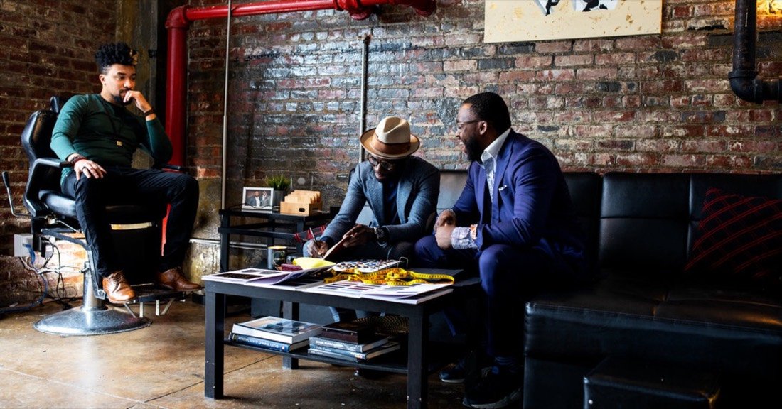 Members in a working session around a table in a brick-walled room